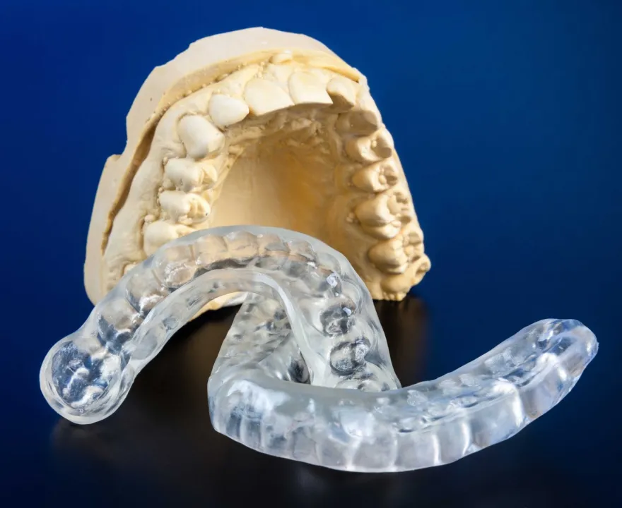 A dental cast fitted with a clear removable splint.
