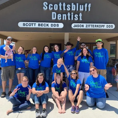 The team in matching shirts gathered under the Scottsbluff Dentist sign.
