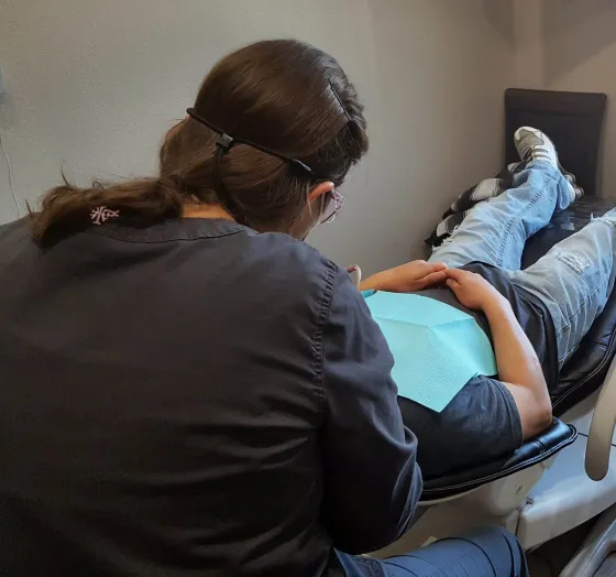 A clinician treating a reclined patient.