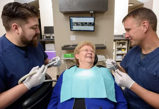 Dr. Beck examining a seated adult patient.